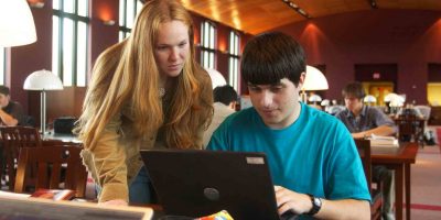 Apply for admission Students looking at a laptop screen
