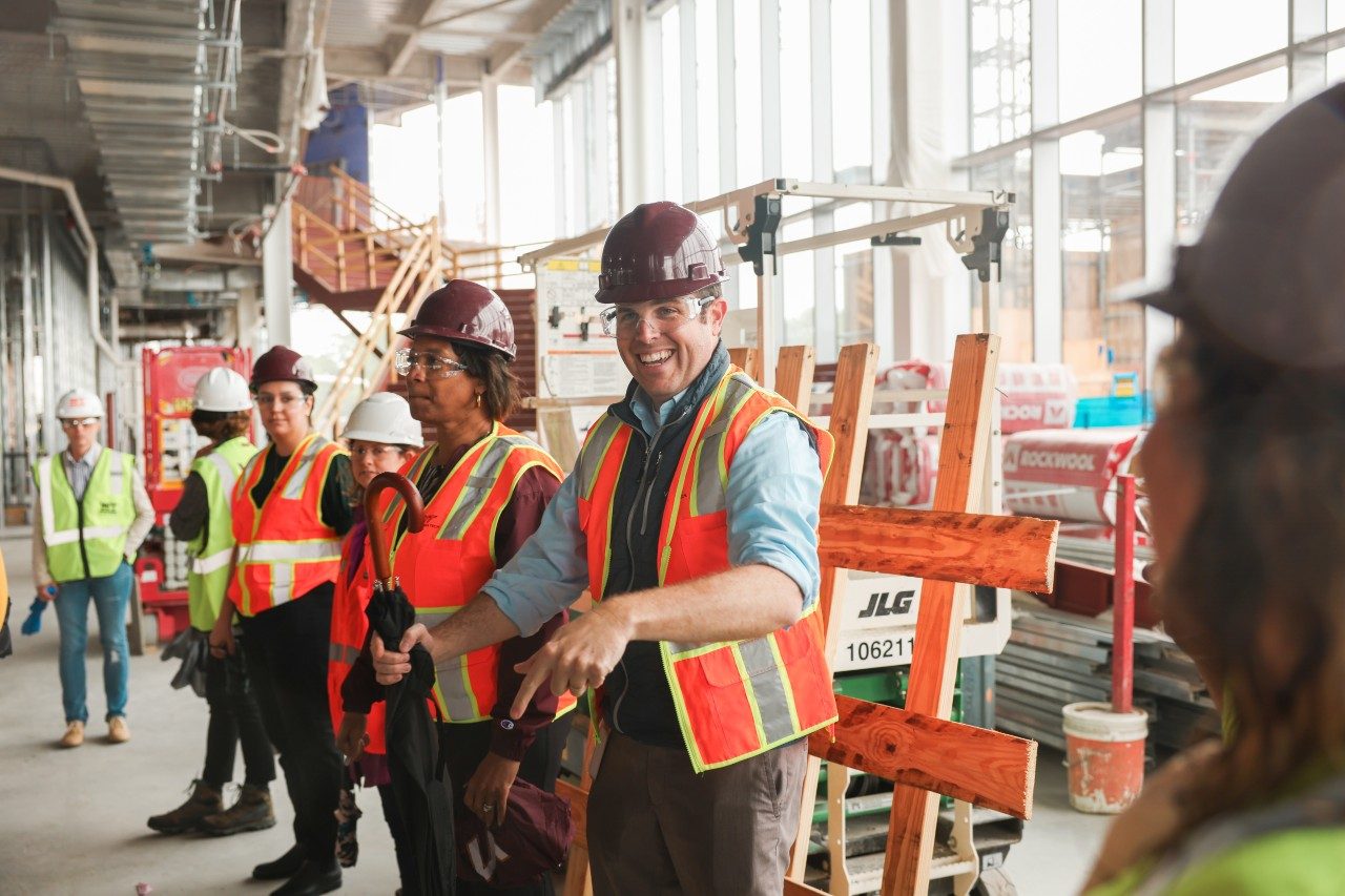 man smiling in group at a construction site