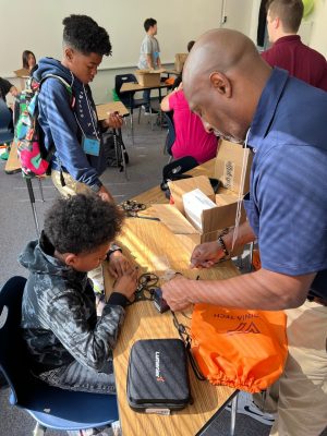 teacher helps students build drones
