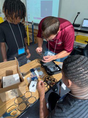 teacher helps students build drones