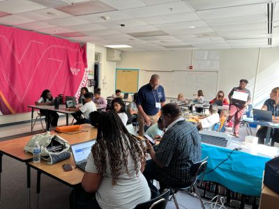 classroom of students and teachers work on computers