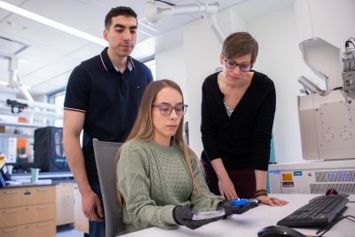 Three researchers looking at a sample.