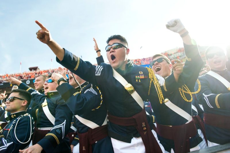 Members of the Corps of Cadets cheer during a football game